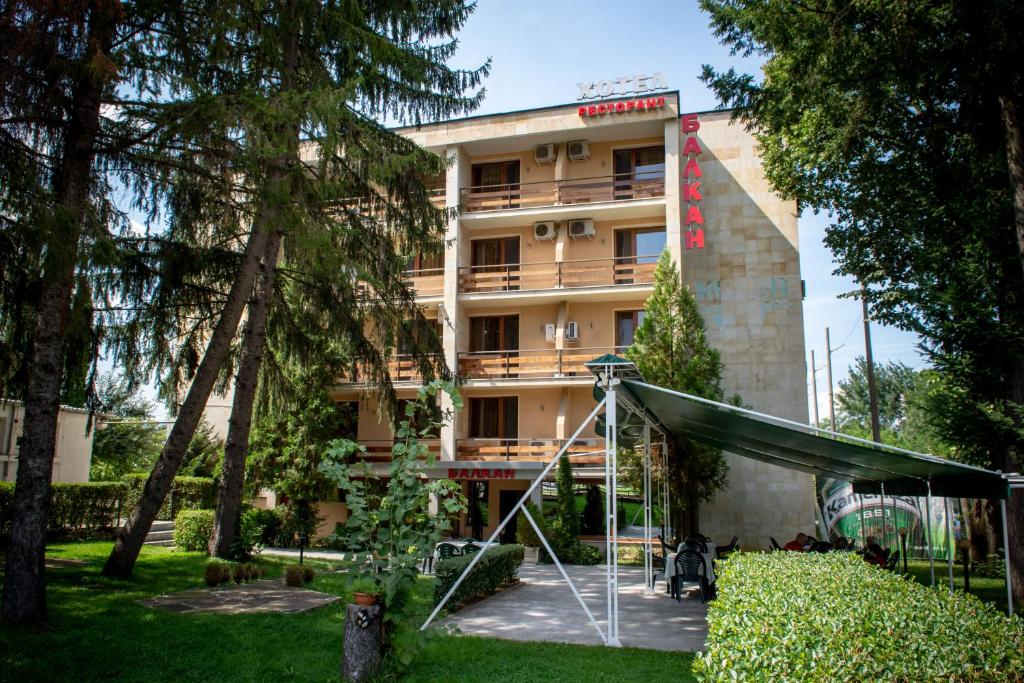 a hotel building with trees in front of it at Hotel Balkan in Botevgrad