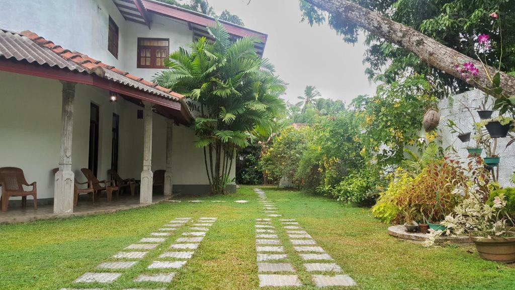 a garden outside a house with a pathway at Villa Happy Home in Bentota
