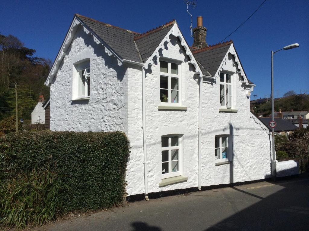 a white house with white windows on a street at Rosevean Cottage St Agnes in St. Agnes