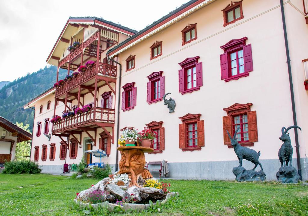 a building with a statue in front of a building at Hotel La Villa della Regina in Gressoney-la-Trinité