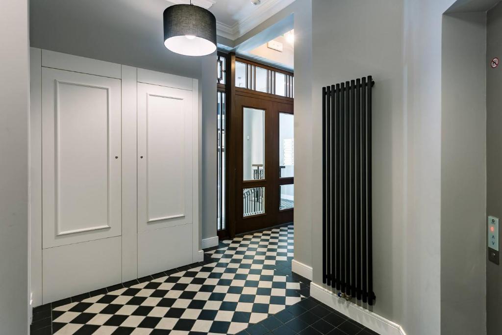 a hallway with a door and a checkered floor at Very Berry - Chełmońskiego 20 - Deluxe Apartments, check in 24h in Poznań