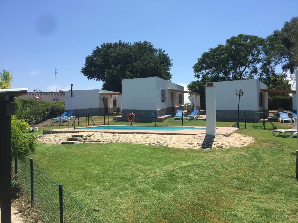 een huis met een zwembad in een tuin bij Villas de la Ermita in Vejer de la Frontera