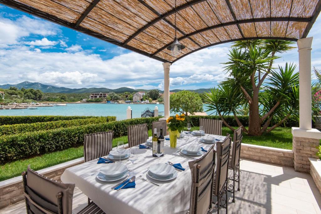 ロヴィステにあるVilla Loviste Paradiseの水辺の景色を望むパティオ(テーブル付)