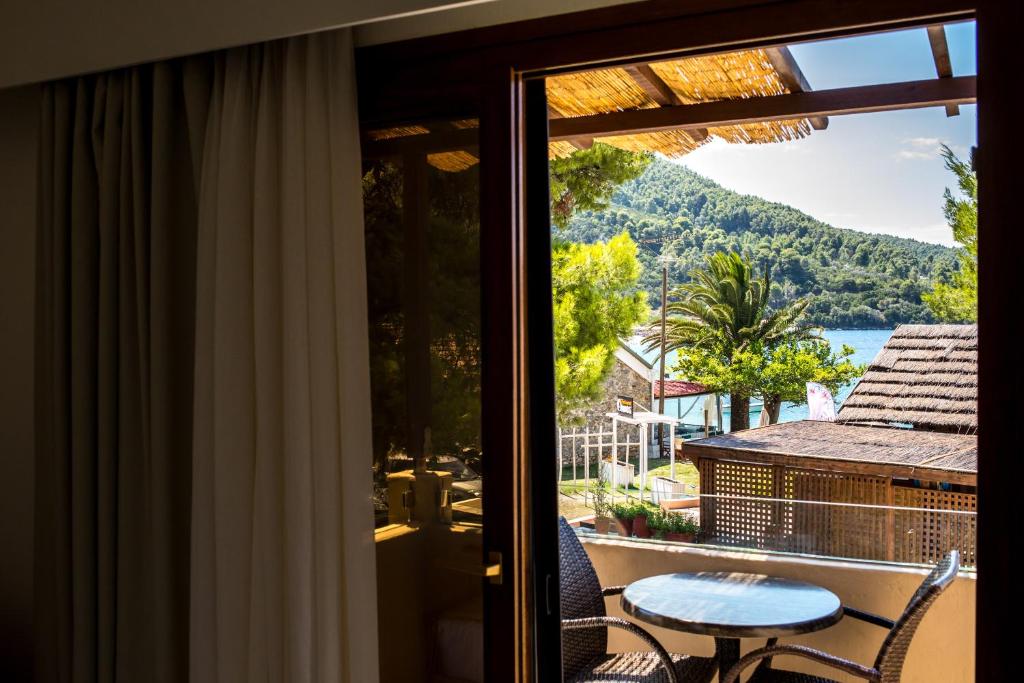 a balcony with a table and a view of the water at Blue Green Bay in Panormos Skopelos