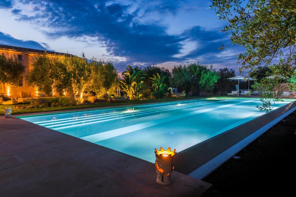 a fire hydrant in front of a swimming pool at Zahir Country House Hotel in Noto