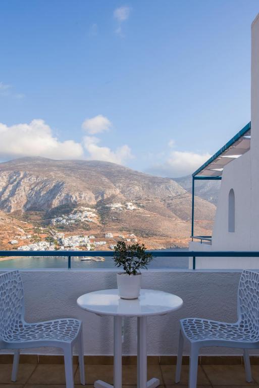 a table and two chairs on a balcony with a view at Aegialis Hotel & Spa in Aegiali