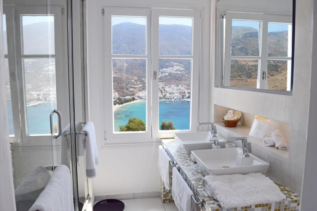 a bathroom with two sinks and two windows at Aegialis Hotel & Spa in Aegiali