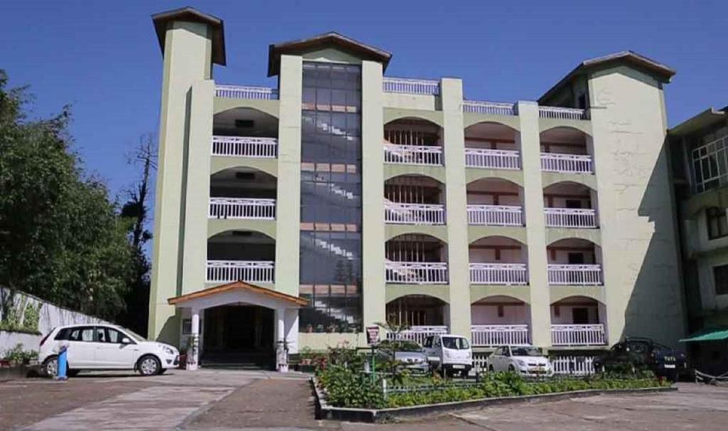 a large building with cars parked in front of it at Landmark Hills in Shillong