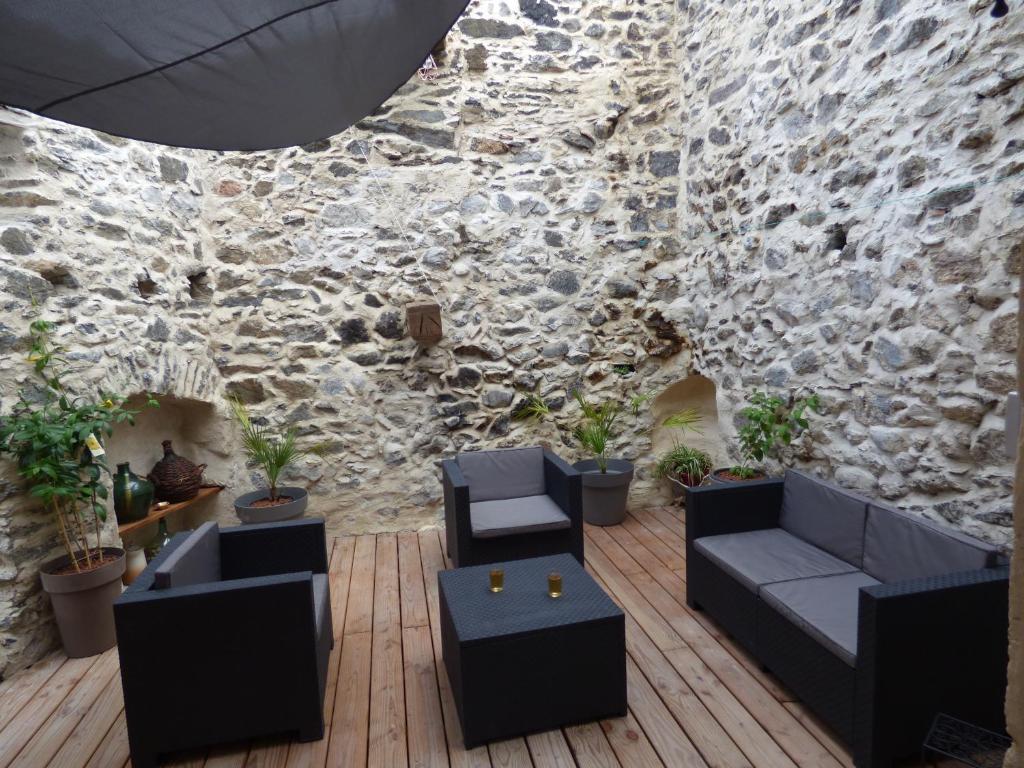 a living room with couches and a stone wall at L'Ostalet in Prugnanes