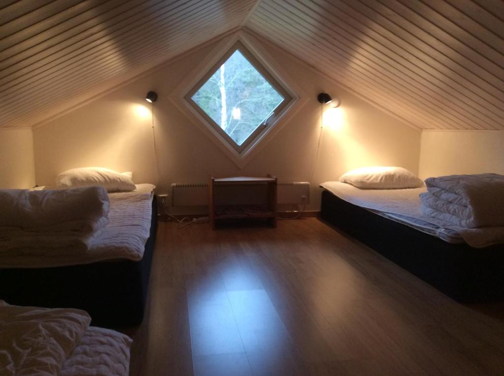 a attic room with two beds and a window at Berghaga 415 in Ullared