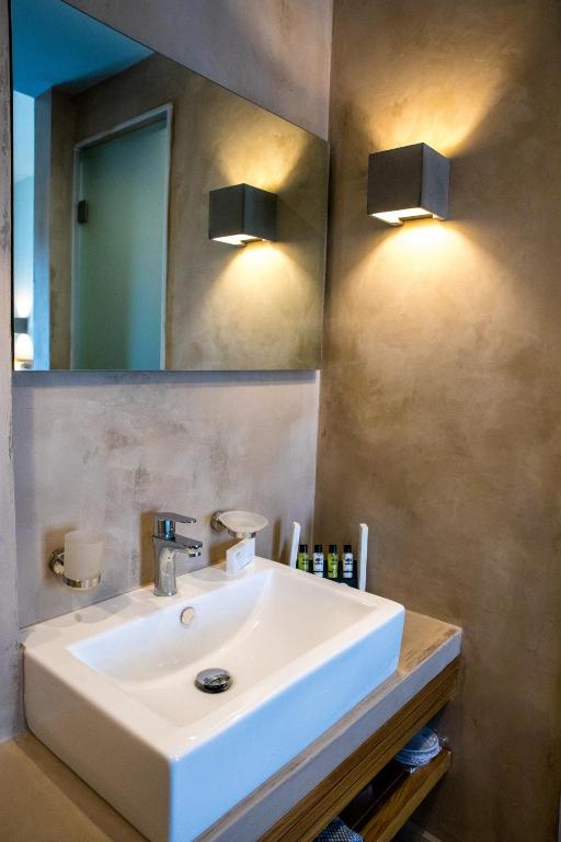 a bathroom with a white sink and a mirror at Blue Green Bay in Panormos Skopelos