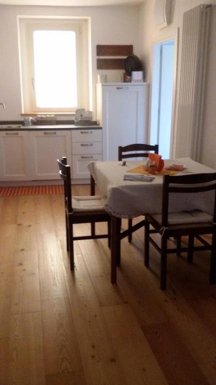 a dining room with a table and chairs and a kitchen at Catif Ladrù in Cerveno