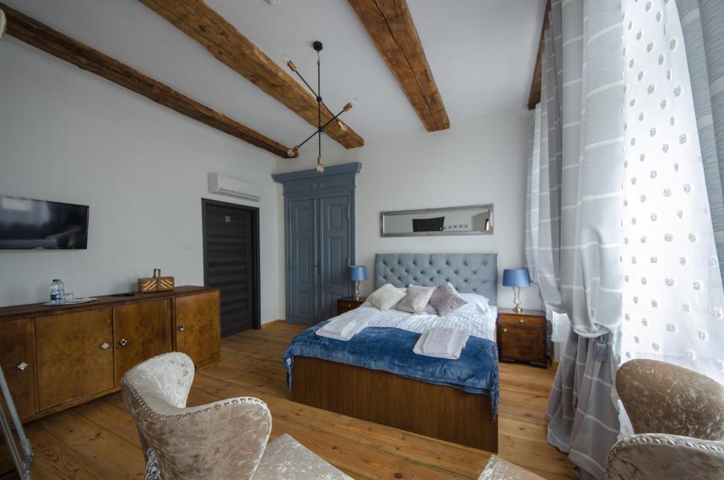 a bedroom with a bed and two chairs at Apartamenty Mieszczańskie u Gołębiewskich in Toruń