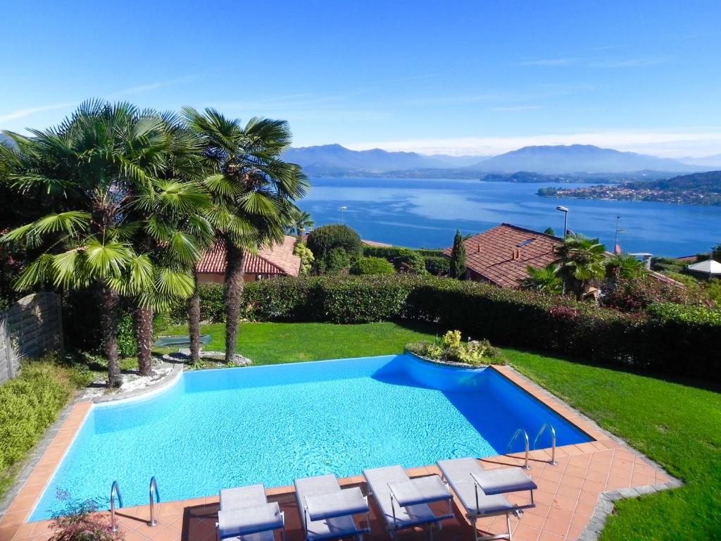 a swimming pool with chairs and a view of the water at Villa Diamante in Meina