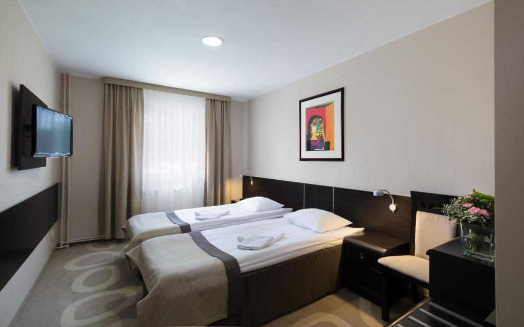 pokój hotelowy z dwoma łóżkami i telewizorem w obiekcie Hotel Picaro Żarska Wieś Południe A4 kierunek Polska w mieście Zgorzelec