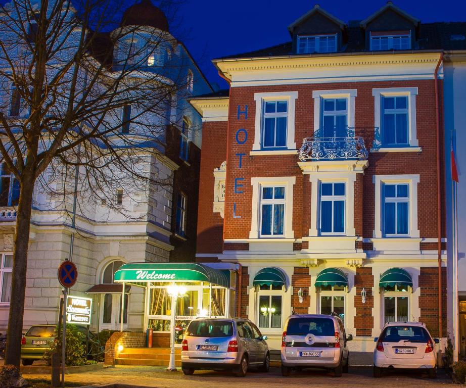 eine Gruppe von Autos, die vor einem Gebäude geparkt sind in der Unterkunft Hotel Hanseatic in Lübeck