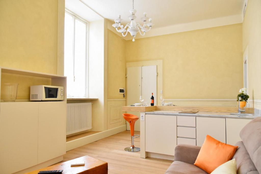 eine Küche und ein Wohnzimmer mit einem Sofa und einem Tisch in der Unterkunft Stella Polare - Luxury apartment in Lucca