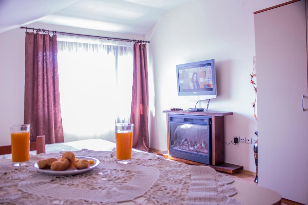 a living room with a table with a plate of food and a fireplace at Bansko home with a Mountain view in Bansko