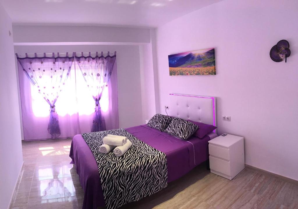 バレンシアにあるBella Vistaのベッドルーム(紫色のベッド1台、窓付)