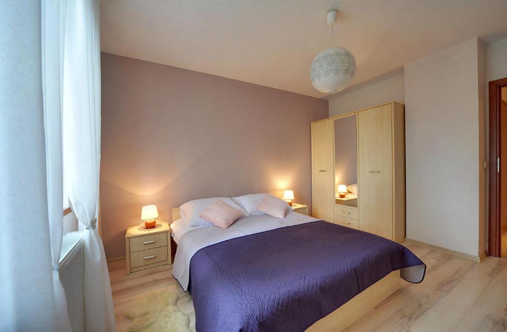 a bedroom with a bed with two night stands and two lamps at Wrzosowy in Karpacz