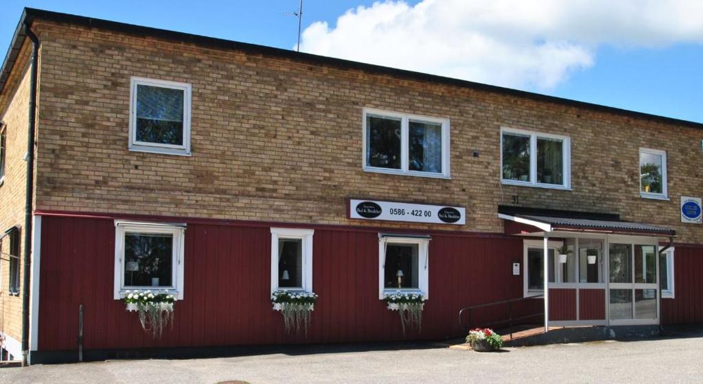 budynek z czerwonej cegły z białymi oknami w obiekcie Lenas Bed & Breakfast w mieście Degerfors