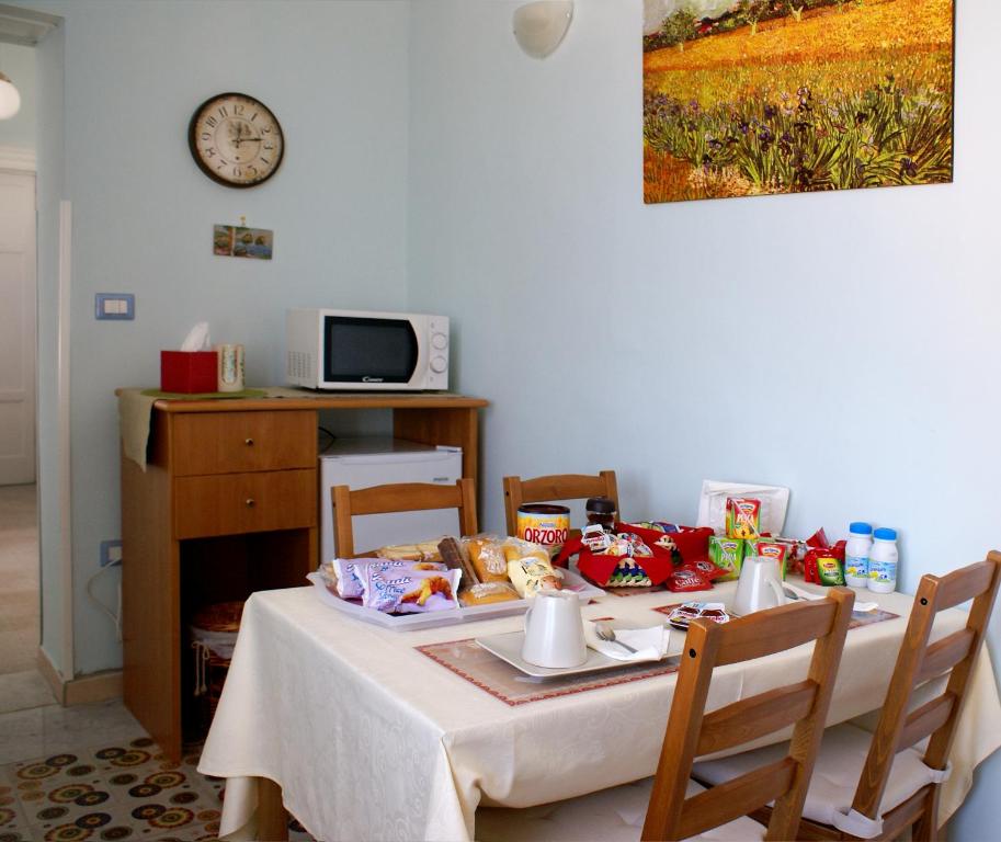 een eettafel met eten erop met een klok bij Bed and Breakfast Sommavesuvio in Pollena Trocchia