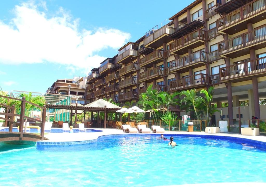 una persona en la piscina de un hotel en Excelentes apartamentos Barra Bali, en Barra de São Miguel