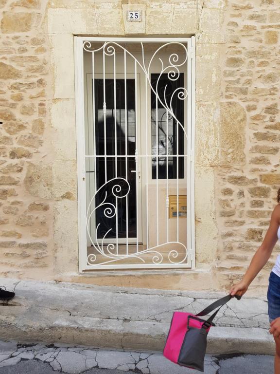 a woman with a pink bag in front of a door at 25 Rue du Roc Appartement in Bagnols-sur-Cèze
