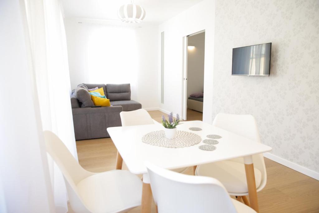 ein weißes Esszimmer mit einem weißen Tisch und weißen Stühlen in der Unterkunft Apartament Plażowy in Giżycko