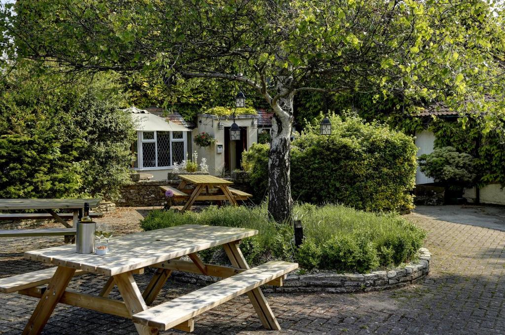 un groupe de tables de pique-nique devant une maison dans l'établissement Best Western Compass Inn, à Tormarton