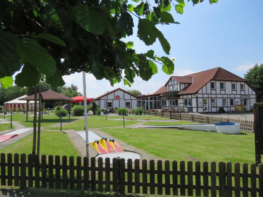 ein Park mit einem Zaun vor einem Gebäude in der Unterkunft Ferienhaus Hanse im Feriendorf Altes Land in Bachenbrock