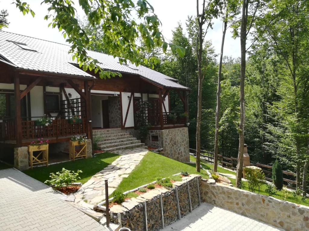 una casa nel bosco con un muro di pietra di Casa Gozna a Văliug