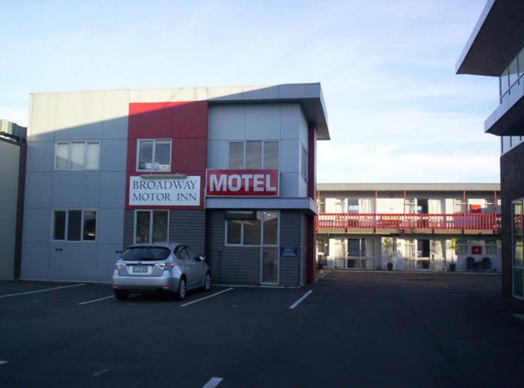 a car parked in a parking lot in front of a motel at Broadway Motor Inn in Palmerston North