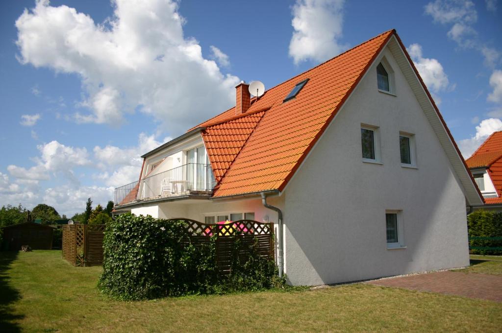 a large white house with an orange roof at Haus Galerie EG in Karlshagen
