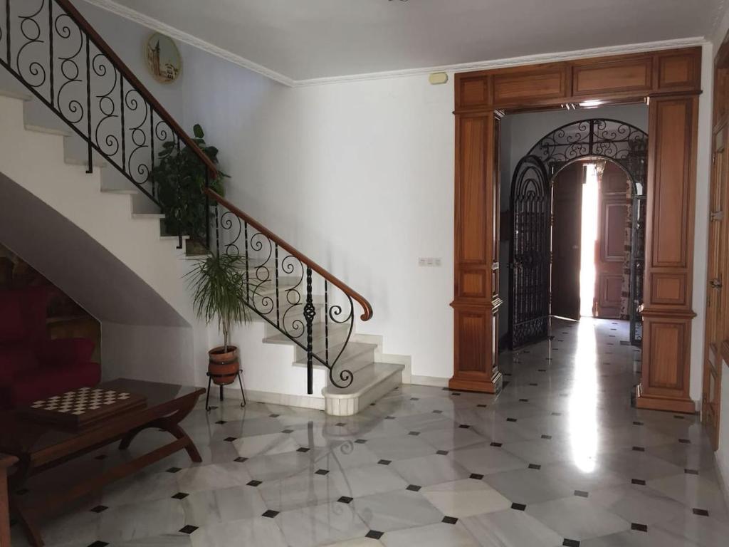 un couloir avec un escalier et une porte dans une maison dans l'établissement Casa del Agüista, à Marmolejo
