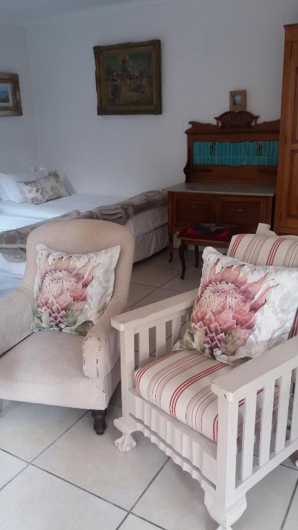 a living room with two chairs and a piano at The Gift in Agulhas