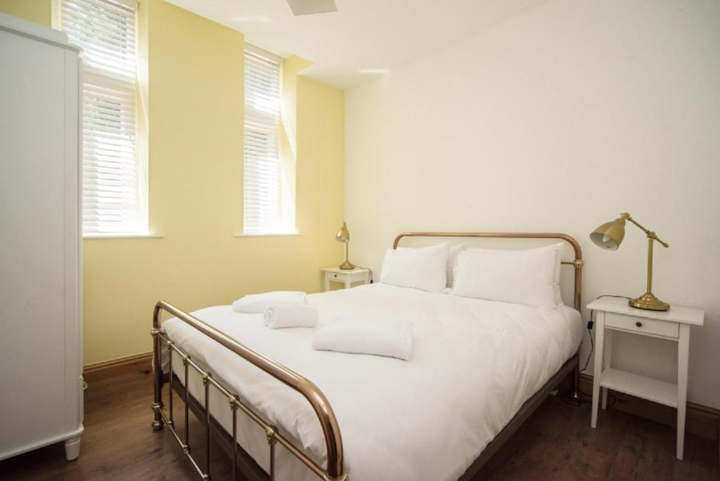 um quarto com uma grande cama branca e 2 almofadas em Marlborough Hall Majestic Apartment - Quiet em Nottingham