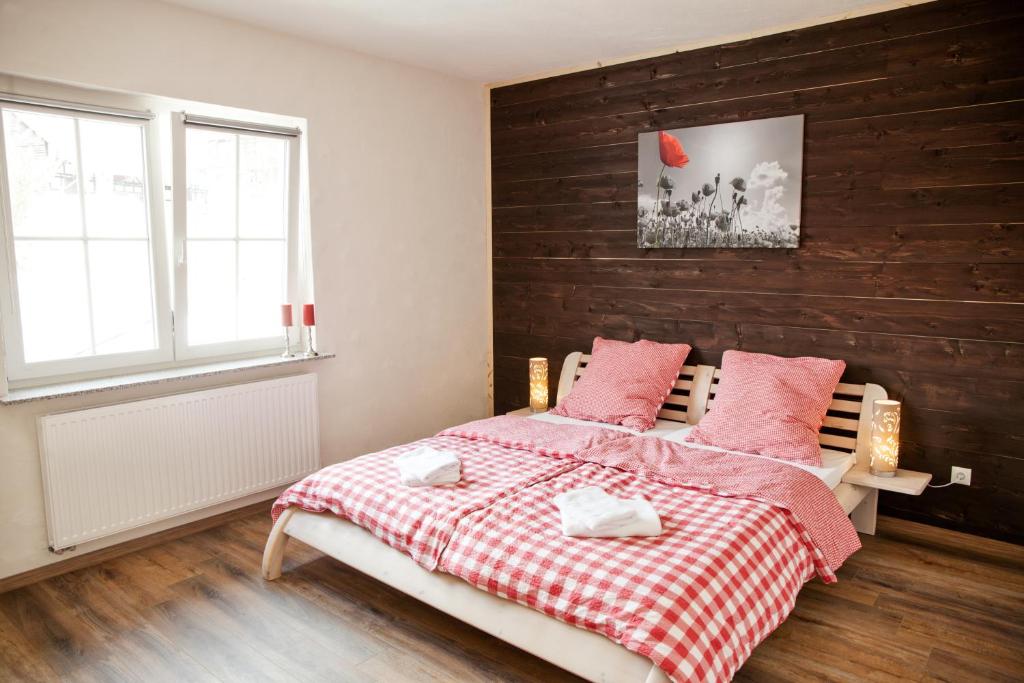 a bedroom with a bed with a red and white blanket at Landhaus im Rinnetal in Homberg