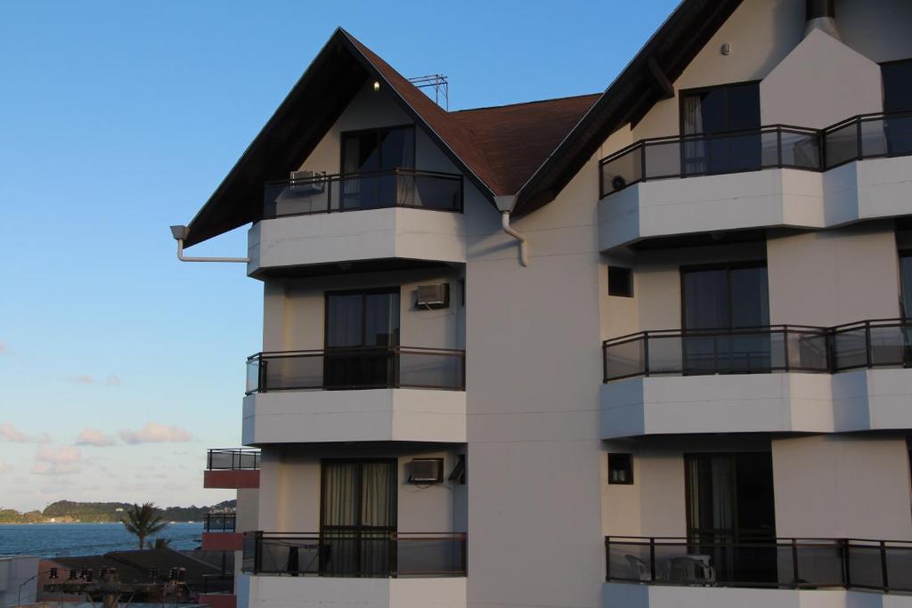 un edificio con balcones y el océano en el fondo en Bomar Residence, en Bombinhas