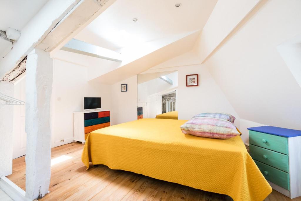 ペリグーにあるPetit studio Saint-Front- Small studio flat Saint-Frontのベッドルーム1室(屋根裏に黄色いベッド1台付)