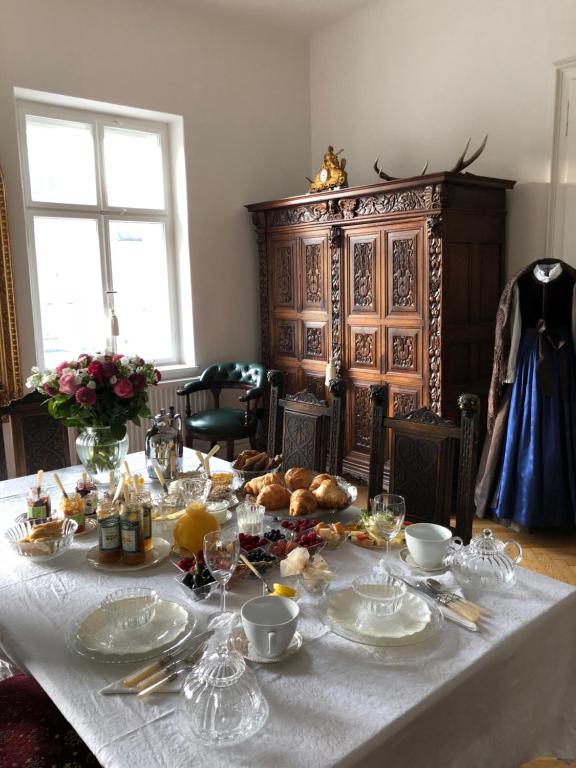 einen Tisch mit einem weißen Tischtuch mit Essen drauf in der Unterkunft Sarah's Altstadt Oase Salzburg in Salzburg