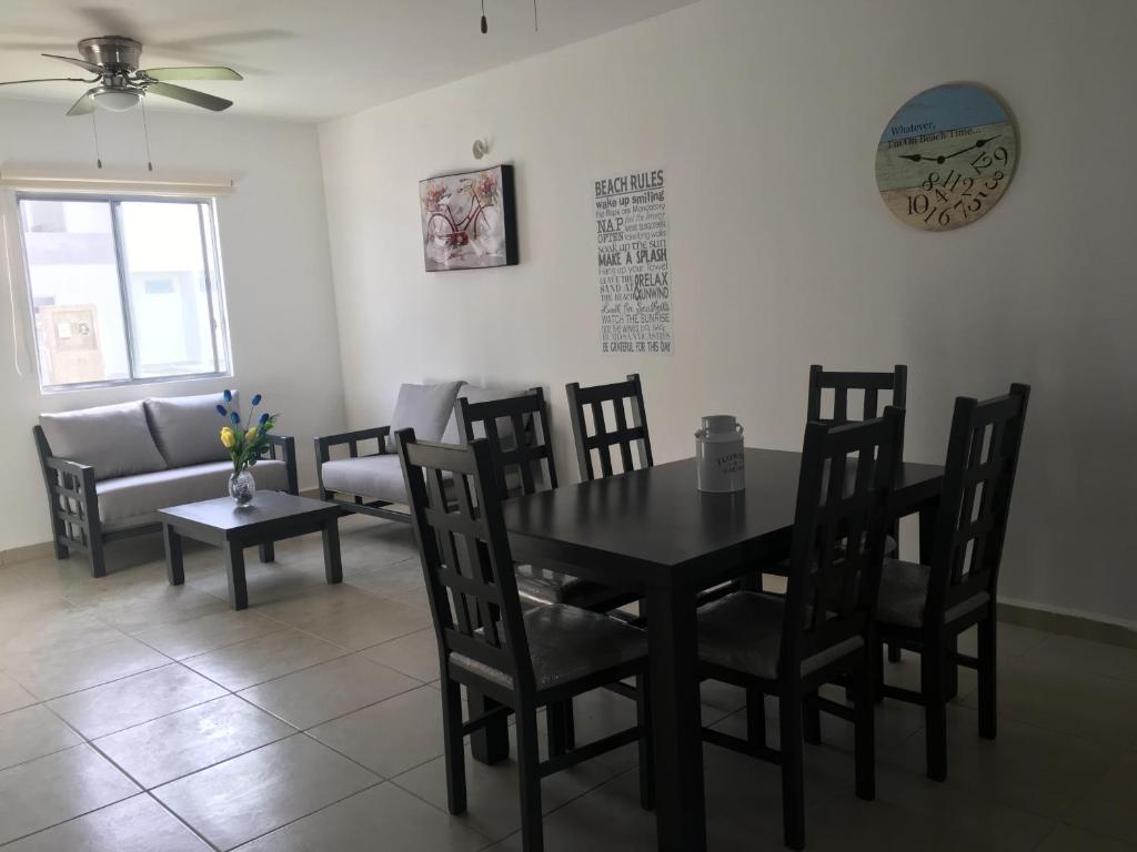 a dining room with a table and chairs and a couch at New House in Puerto Morelos, Riviera Maya in Puerto Morelos