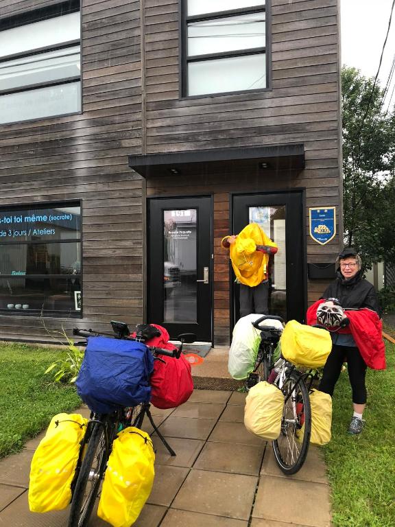 a woman standing next to three bikes with bags on them at Gîte Zazen in Mont-Laurier