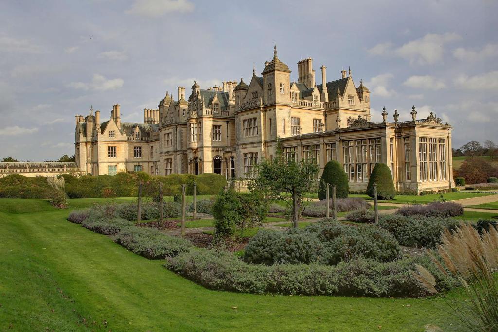 a large castle with a garden in front of it at Stoke Rochford Hall in Grantham