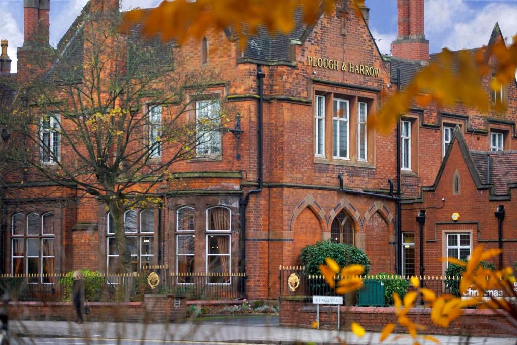 ein rotes Backsteingebäude mit einem Baum davor in der Unterkunft Best Western Plough and Harrow Hotel in Birmingham