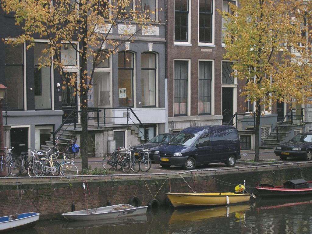 a van parked on the side of a river with bikes at B&B Singel 100 in Amsterdam