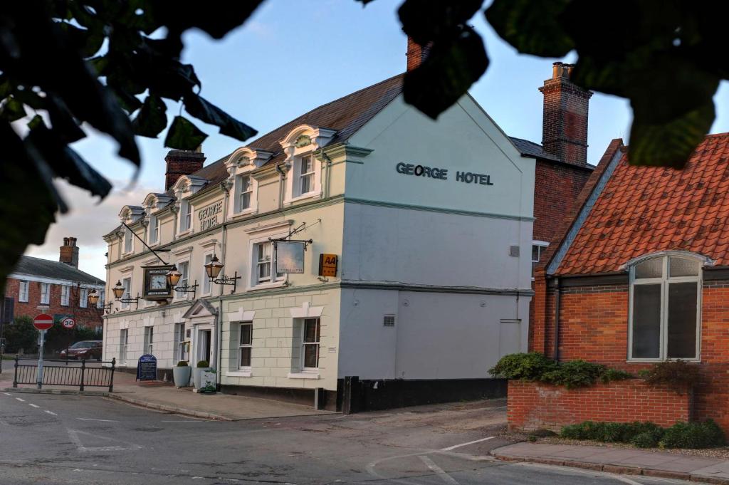 a white building with a sign on the side of it at Best Western The George Hotel, Swaffham in Swaffham