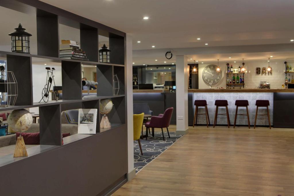 un vestíbulo con bar y algunos taburetes en Best Western White House Hotel, en Watford