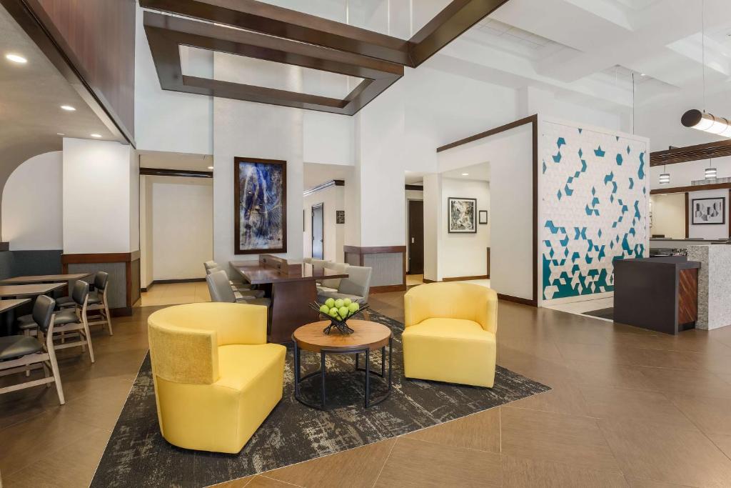 a lobby with yellow chairs and a table at Hyatt Place Dallas/Grapevine in Grapevine