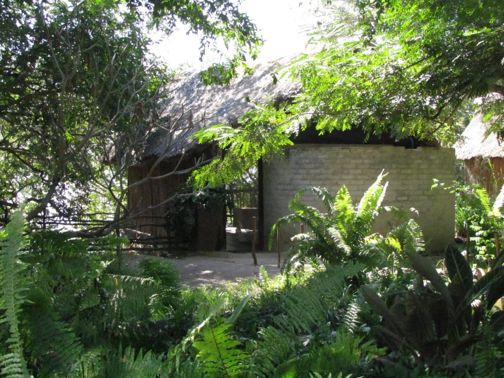 an old brick building in the middle of a garden at Caprivi Houseboat Safari Lodge in Katima Mulilo